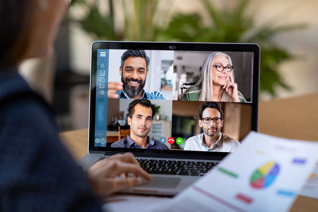 Una persona vista desde detrás haciendo una videoconferencia con cuatro alumnos.